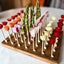 bamboo pick board featuring veggies skewered on toothpicks